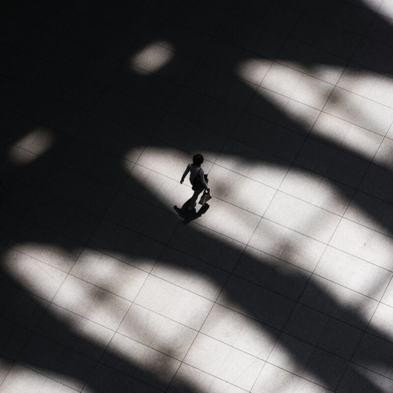 Man walking in the shadows photo from above at an angle