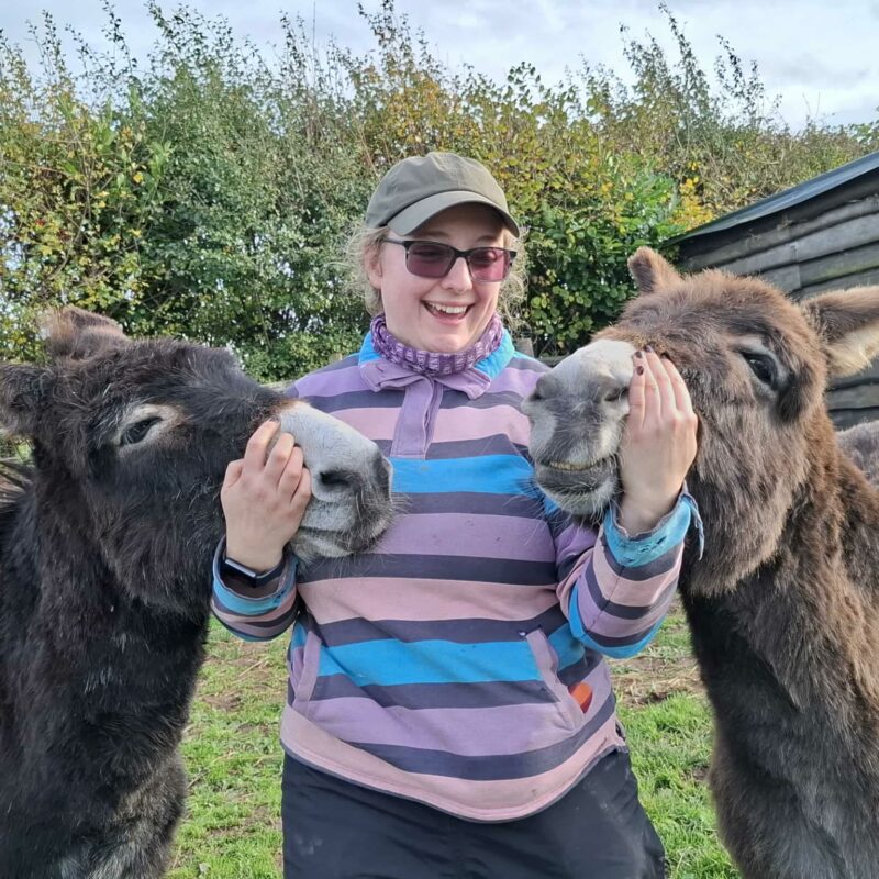 TJ Gibbons petting two donkeys, sharing her mental health story with Don't Hide